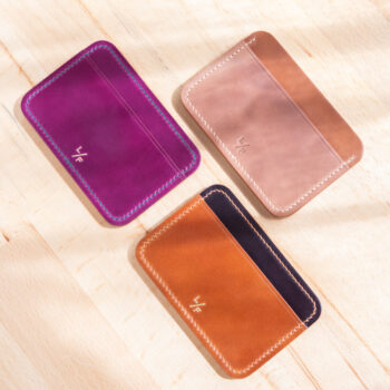 Three leather card wallets in a variety of colors.